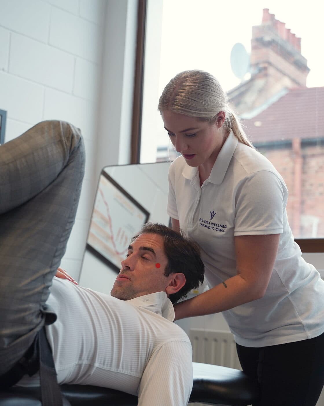 Bianca Downey working on a reclined patient's head and neck on the treatment table.