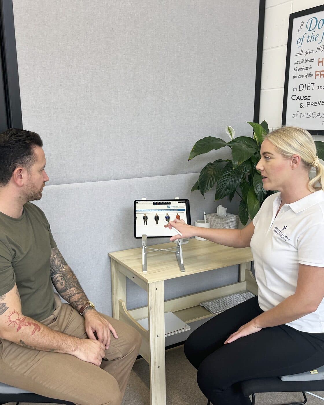 Bianca Downey talking a patient through his results on the tablet at the consultation desk.
